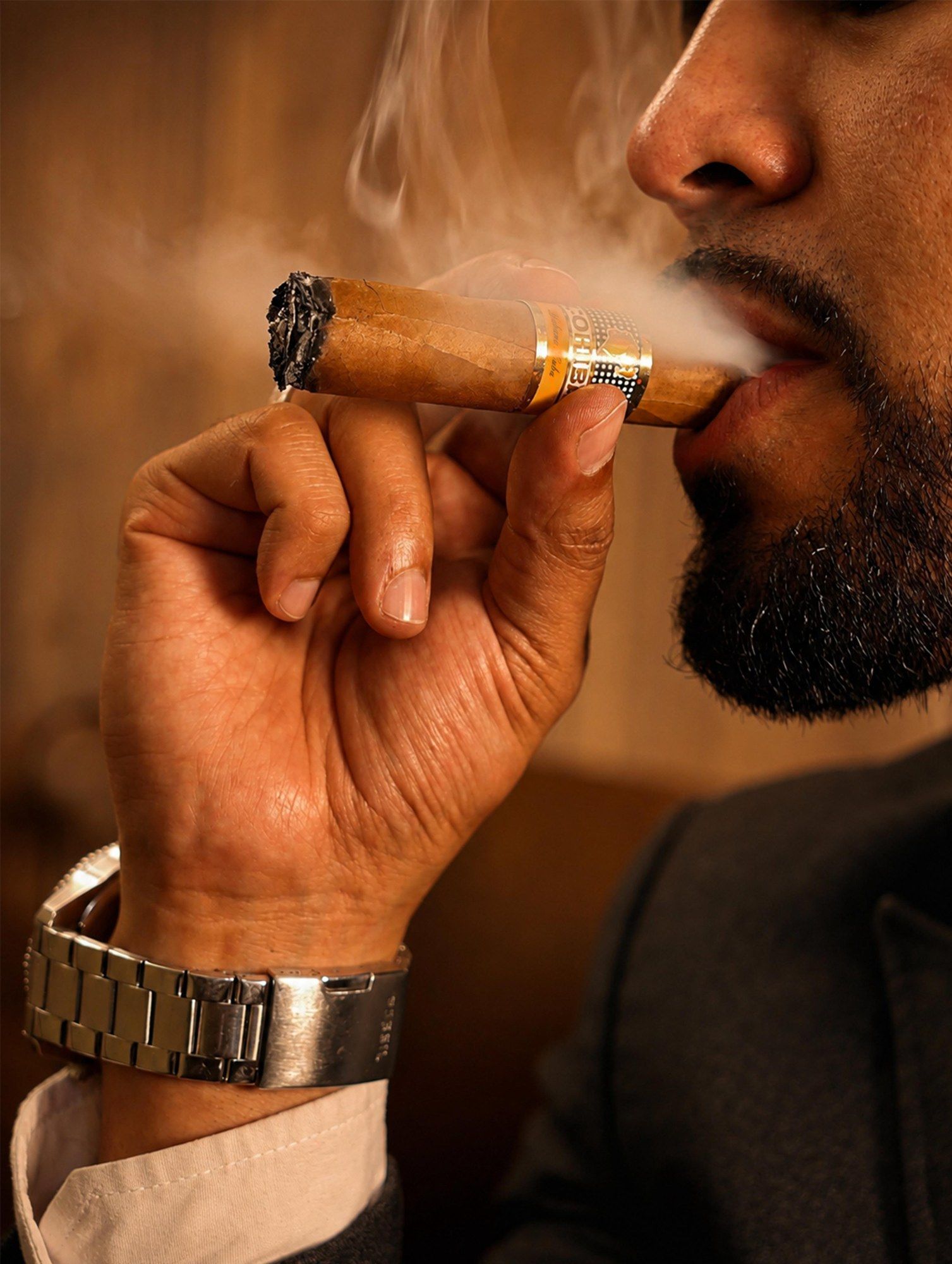 Primer plano de un habano encendido y su humo